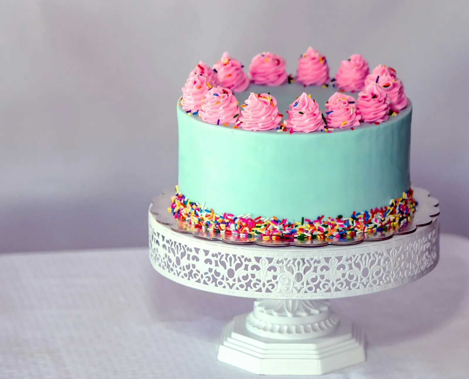 Torta color menta con merengues rosados y chispas
